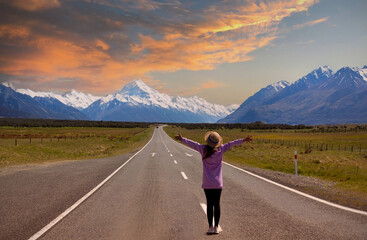 Happy lifestyle of freedom young tourist woman  on the road with landscape view of sunset sky scene background over Mount Cook