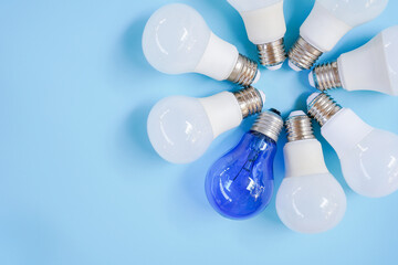 Top view of white and blue light bulb in circle with copy space on light blue background ,...