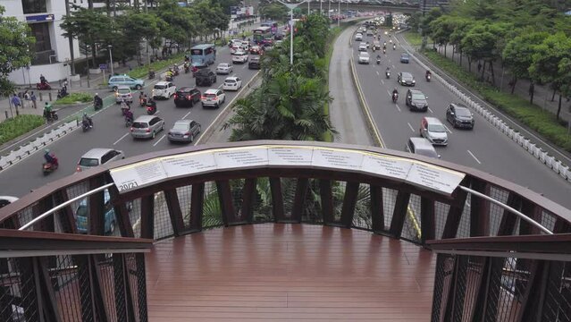 Jakarta, Indonesia - December 24, 2022 : Workers walking on the JPO (Pedestrian Bridge Pinisi) during work hours