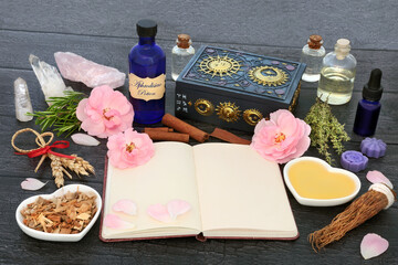 Aphrodisiac love potion recipe ingredients with magic spell notebook with herbs, rose flowers,...