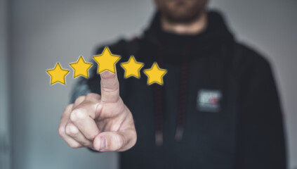 close up on man hand press on smartphone screen with gold five star rating feedback icon and press level excellent rank for giving best score point to review the service technology business