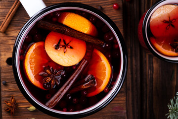 A white ladle with boiled mulled wine stands on a wooden table