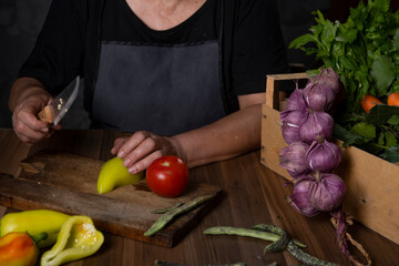 woman cutting vegetables on wooden board