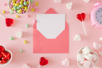 Fototapeta St Valentines Day concept. Flat lay composition made of pink alarm clock, heart shaped saucers with candies and marshmallow on pastel pink background with envelope in the middle. obraz