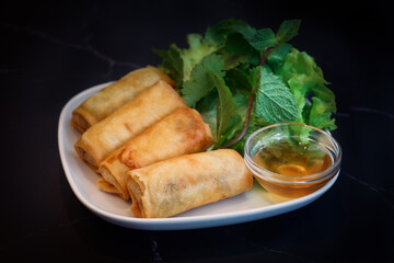 A crispy deep fried spring rolls wrapped stuffed with rice vermicelli and assorted veggies in a...
