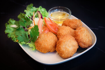 Thai traditional deep fry shrimp patty in a plate on table with sweet plum sauce with isolated...