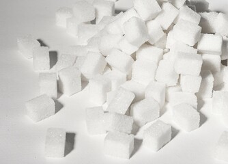 Refined sugar cubes pieces in pile, heap. Overconsumption of sugary products, unhealthy food, snacks concept