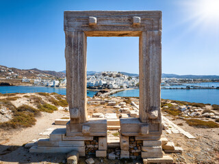 View through the famous Portara marble gate of Naxos island to the city and harbour, Cyclades, Greece - obrazy, fototapety, plakaty