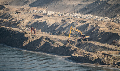 Excavator Machine at Excavation Earthmoving in Sand Quarry by river. environment pollution concept.