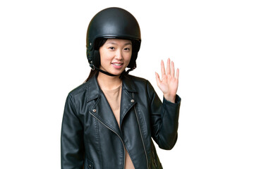 Young Asian woman with a motorcycle helmet over isolated chroma key background saluting with hand with happy expression