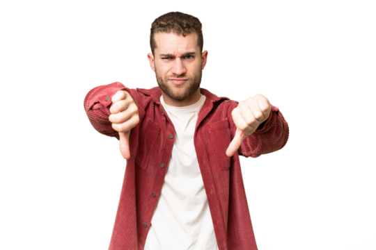 Young handsome blonde man over isolated chroma key background showing thumb down with two hands