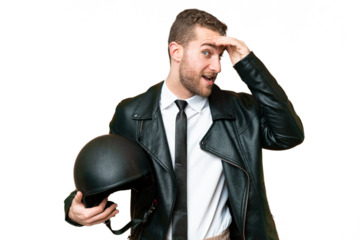 Business man with a motorcycle helmet over isolated chroma key background doing surprise gesture while looking to the side