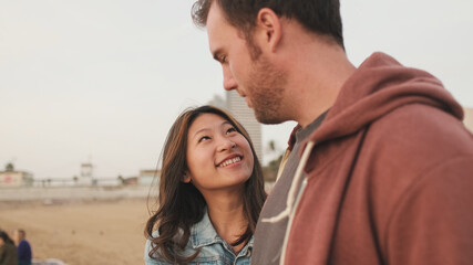 vMan and woman talking while standing on the beach