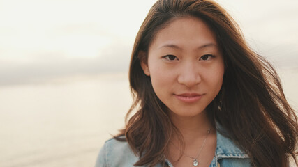 Close-up of laughing beautiful young woman looking at camera