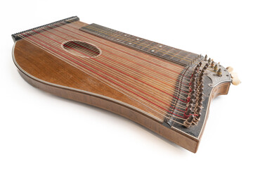 High angle closeup horizontal studio shot of vintage, old wooden zither isolated on white background. Detail of zither mechanics and tuning pins. Dusty and scratched instrument.