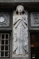 Obraz premium Amsterdam Bazel Building Exterior Close Up with Sculpture of a Standing Female Figure with Closed Eyes Representing Asia, Netherlands