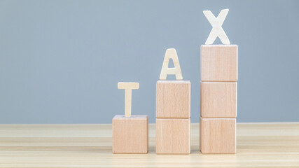 wood cube block with "TAX" text . Financial, Management, Economic, business and time to tax concept