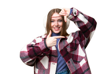 Young pretty woman wearing winter muffs over isolated chroma key background focusing face. Framing symbol