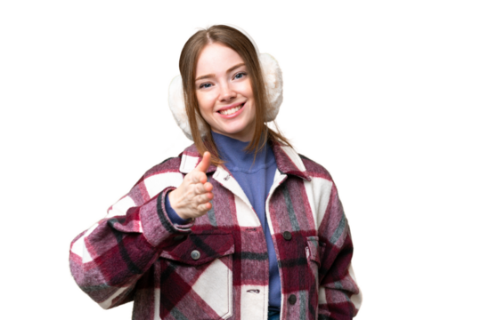 Young pretty woman wearing winter muffs over isolated chroma key background shaking hands for closing a good deal