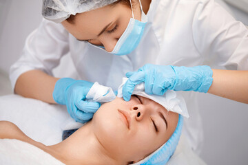 woman during a mechanical face cleansing procedure
