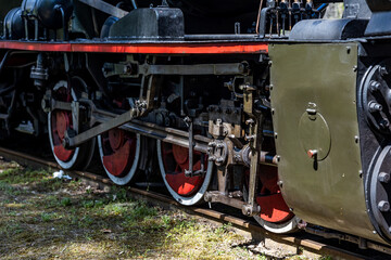 Close-up of the driving wheels of a steam locomotive. Steam locomotive parked on the forest station.