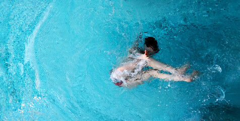 top view to young sexy bikini woman in turquoise pool spa has fun under water and reaches hand out to you and invites you