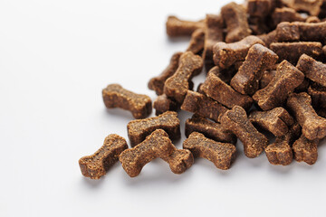 Granules of dry feed in the shape of a bone. for dogs on a white background.