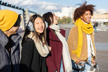 Multiracial group of young friends having fun outside in the city. Happy diverse student people...