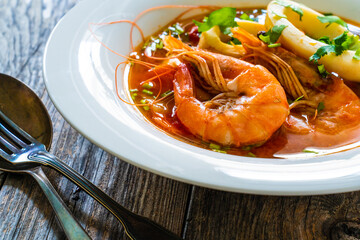 Seafood soup on wooden table
