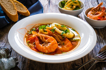 Seafood soup on wooden table
