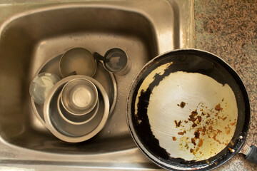 Lived in interior with unfinished and dirty utensils kept in sink for washing