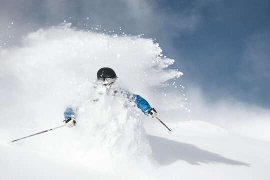 Male skier skies through a burst of deep powder at Breckenridge Resort