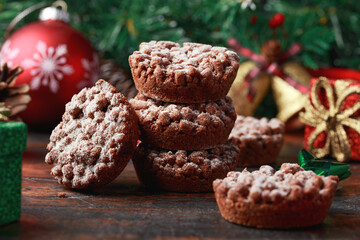 Christmas chocolate mince pies with decoration, gifts, green tree branch on wooden rustic table