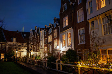 Fototapeta na wymiar Amsterdam street at night, well illuminated houses. Home decoration