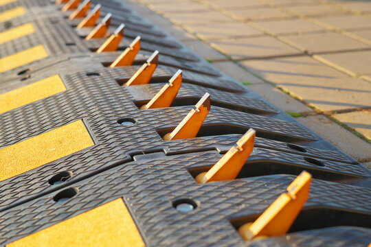 One Way Traffic Speed Bump With Spikes Is On The Road.