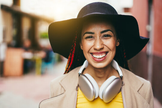 Mixed race girl listen playlist music with headphones outdoor - Focus on face
