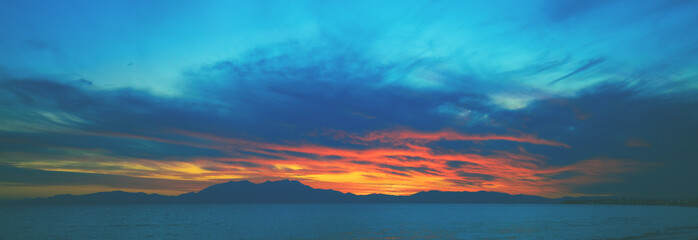 Seascape in the evening during sunset. Landscape with Aegean sea and Mount Olympus on the horizon. Aegean sea in Chalkidiki, Greece, Europe. Horizontal banner