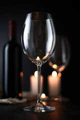 Elegant red wine glass and a wine bottle in black background