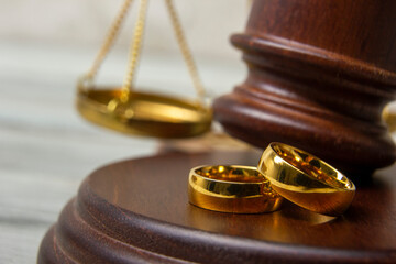 Divorce concept. Law and Justice background. Judge gavel on with two golden wedding rings