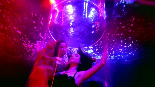 two fashion models floating in water with red and blue illumination, underwater shot
