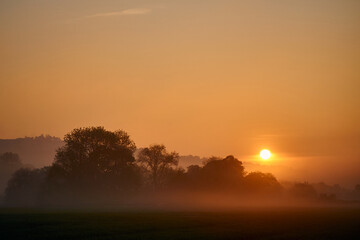 Fototapeta na wymiar Sunrise over a misty field