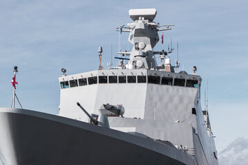 Front view of a large gray army warship armed with a cannon and a machine gun turret © Armands photography