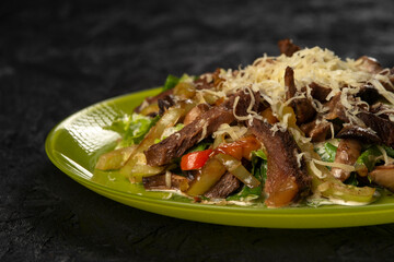 beef salad with vegetables on black background