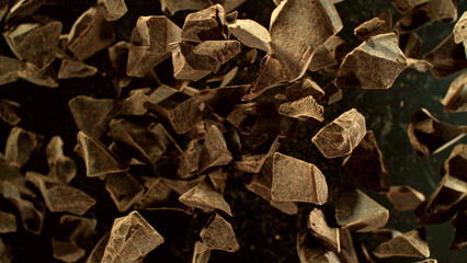Freeze motion of flying group of raw chocolate pieces.