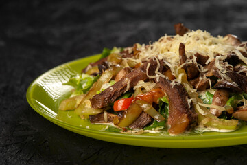 beef salad with vegetables on black background