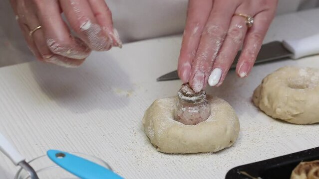 A woman makes buns in the form of flowers. Makes blanks for jaj rolls. Close-up.