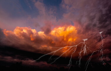 lightning on fiery clouds in the sky, colorful dramatic sky with clouds and steaming cumulonimbus...