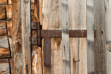 Wooden Fence Door View with Weathered Wall Planks, Old Rusty Hinges and Chains. Agricultural Livestock Building Tree Texture Background	