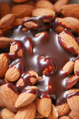 dark chocolate cream pouring on almond nut on white 