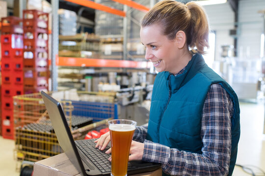 female worker using laptop in brewery
